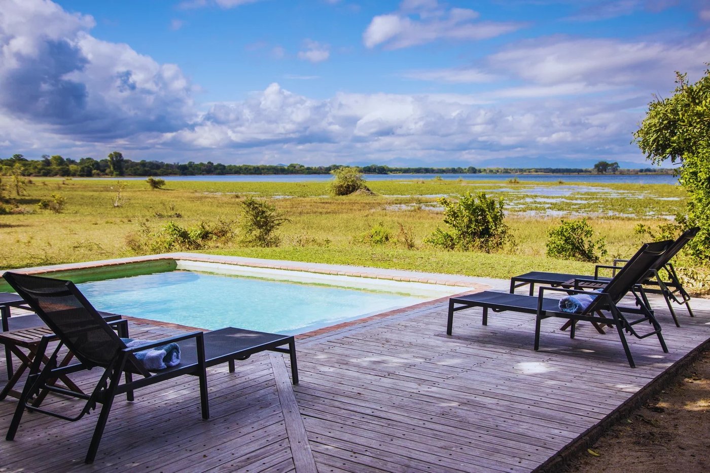Plunge-Pool und Liegestühle mit Blick auf die offene Überschwemmungsebene in Kuthengo Camp