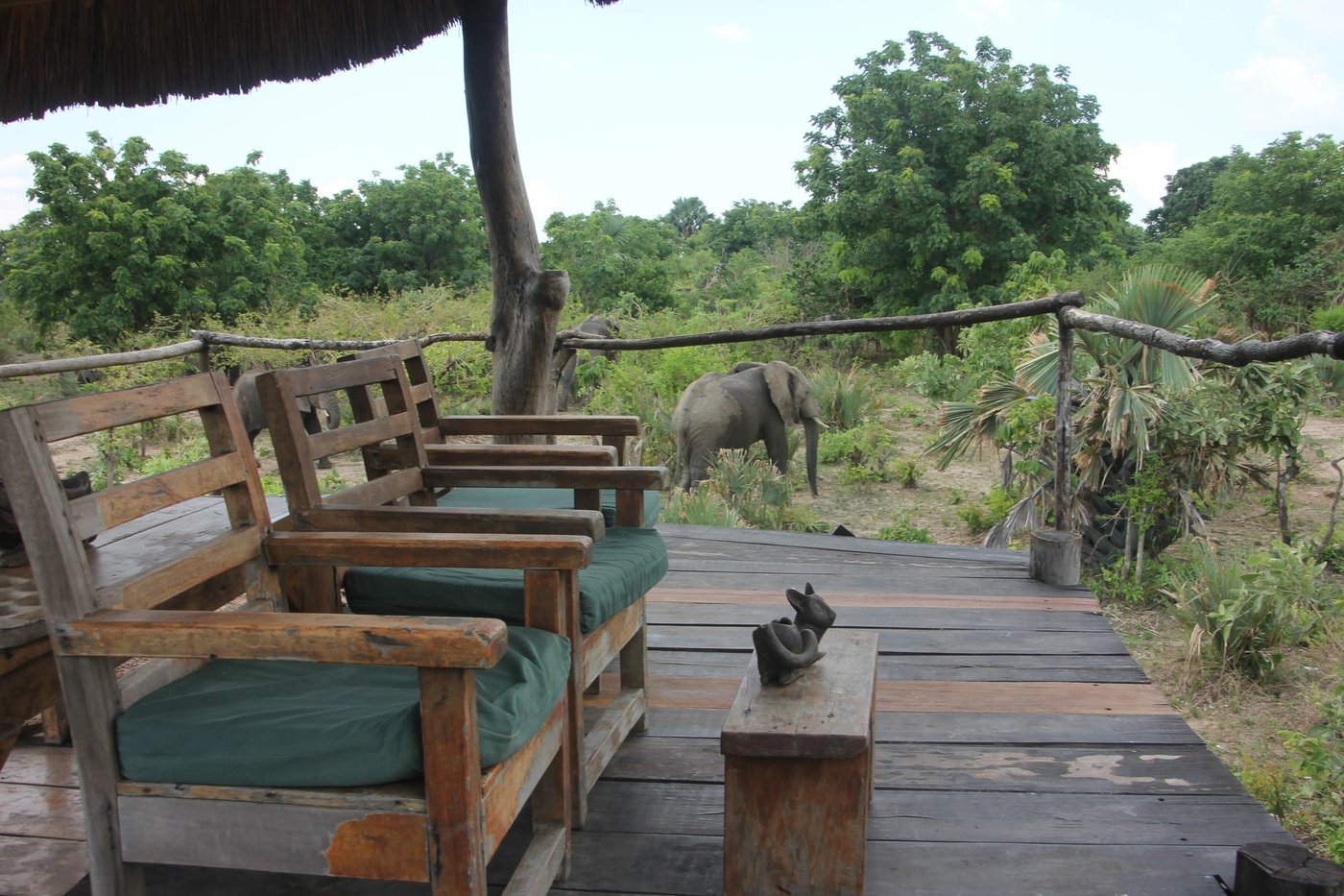 Holzterrasse mit Blick auf Elefanten, die das Gebüsch am Liwonde Safari Camp durchsuchen