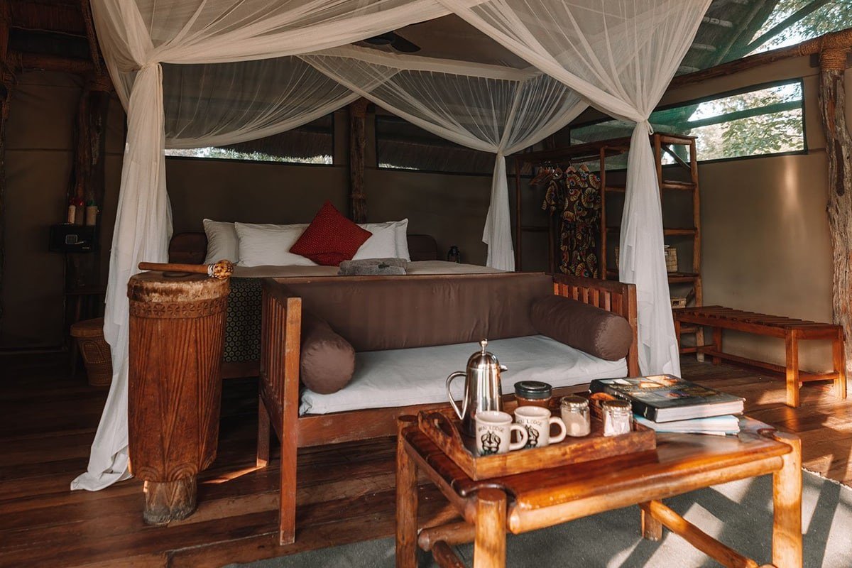 Himmelbett und Tagesbett in einem strohgedeckten Zimmer in Mvuu Lodge